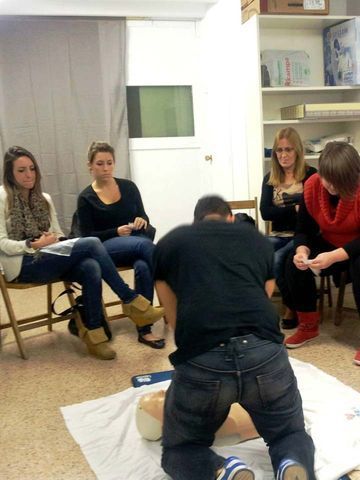 Un grupo de personas están sentadas alrededor de un hombre de rodillas.