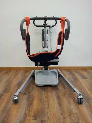 Una silla de ruedas está sentada sobre un piso de madera en una habitación.