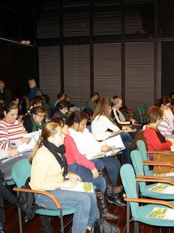 Un grupo de personas están sentadas en sillas en una habitación.