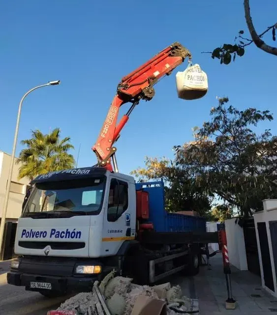 Un camión de pachón de polvo con una grúa acoplada.