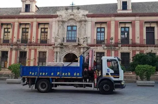 Un camión azul y blanco está estacionado frente a un edificio.