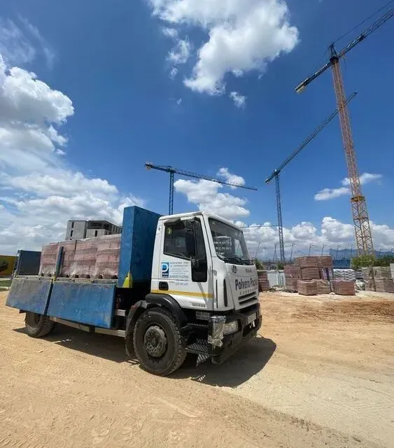 Un camión azul y blanco está estacionado en un camino de tierra.