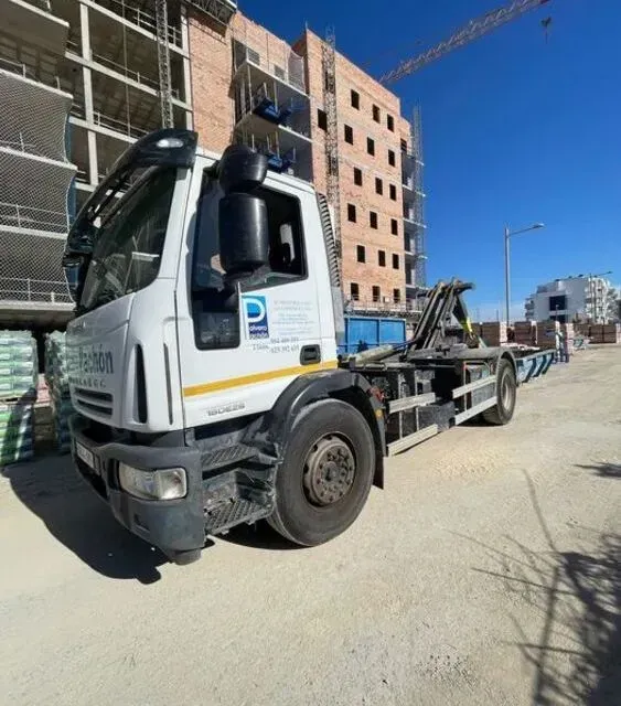 Un camión Falcon está estacionado frente a un edificio en construcción.