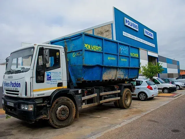 Un camión volquete está estacionado frente a un edificio.