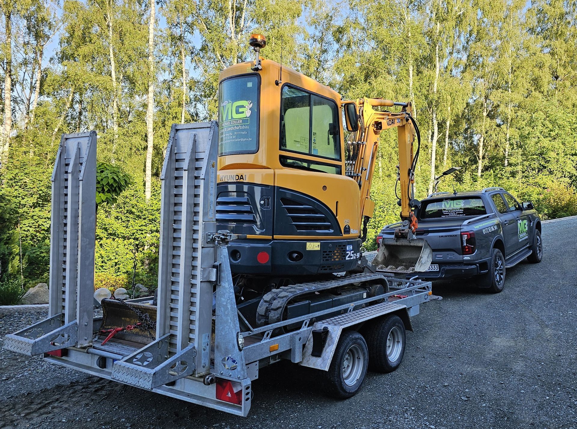 Ein gelber Bagger und ein Bulldozer bewegen Erde auf einer Wohnbaustelle.