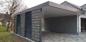 Eine offenen Garage mit Flachdach und einer Stützwand aus Natursteinen