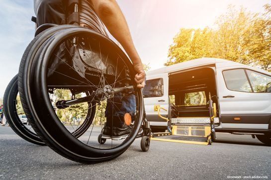 Rollstuhlfahrer fährt auf einen Transporter zu