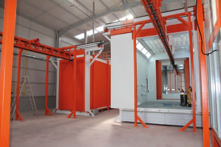 Ein großes orange-weißes Gebäude, durch das ein Förderband verläuft.