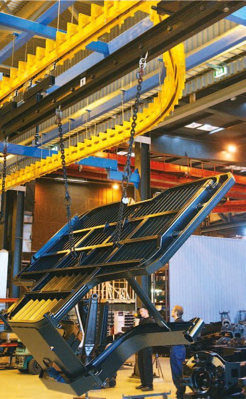 Ein großes Stück Metall hängt an einem Kran in einer Fabrik