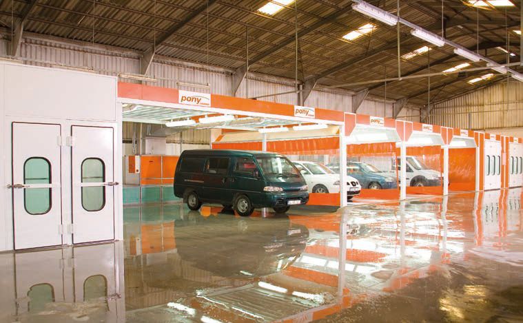 Ein schwarzer Lieferwagen steht in einer großen Lagerhalle.