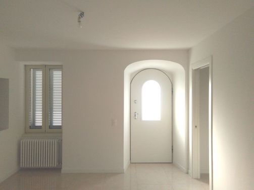 Interno di una casa con arco e pareti bianche
