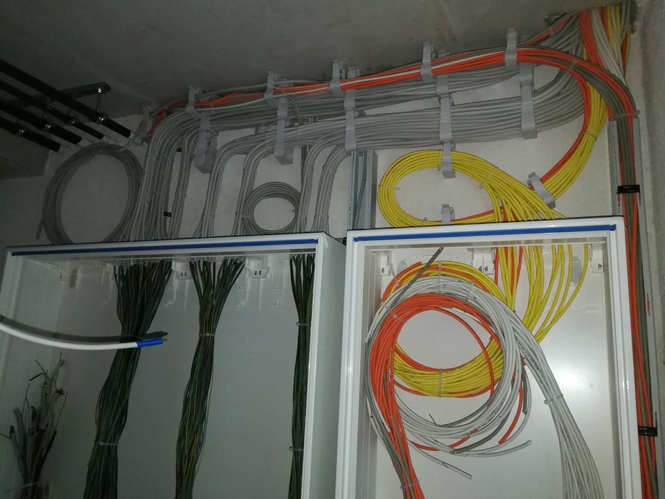 In einem Schaltschrank sind Drähte unterschiedlicher Farben und Stärken geordnet.