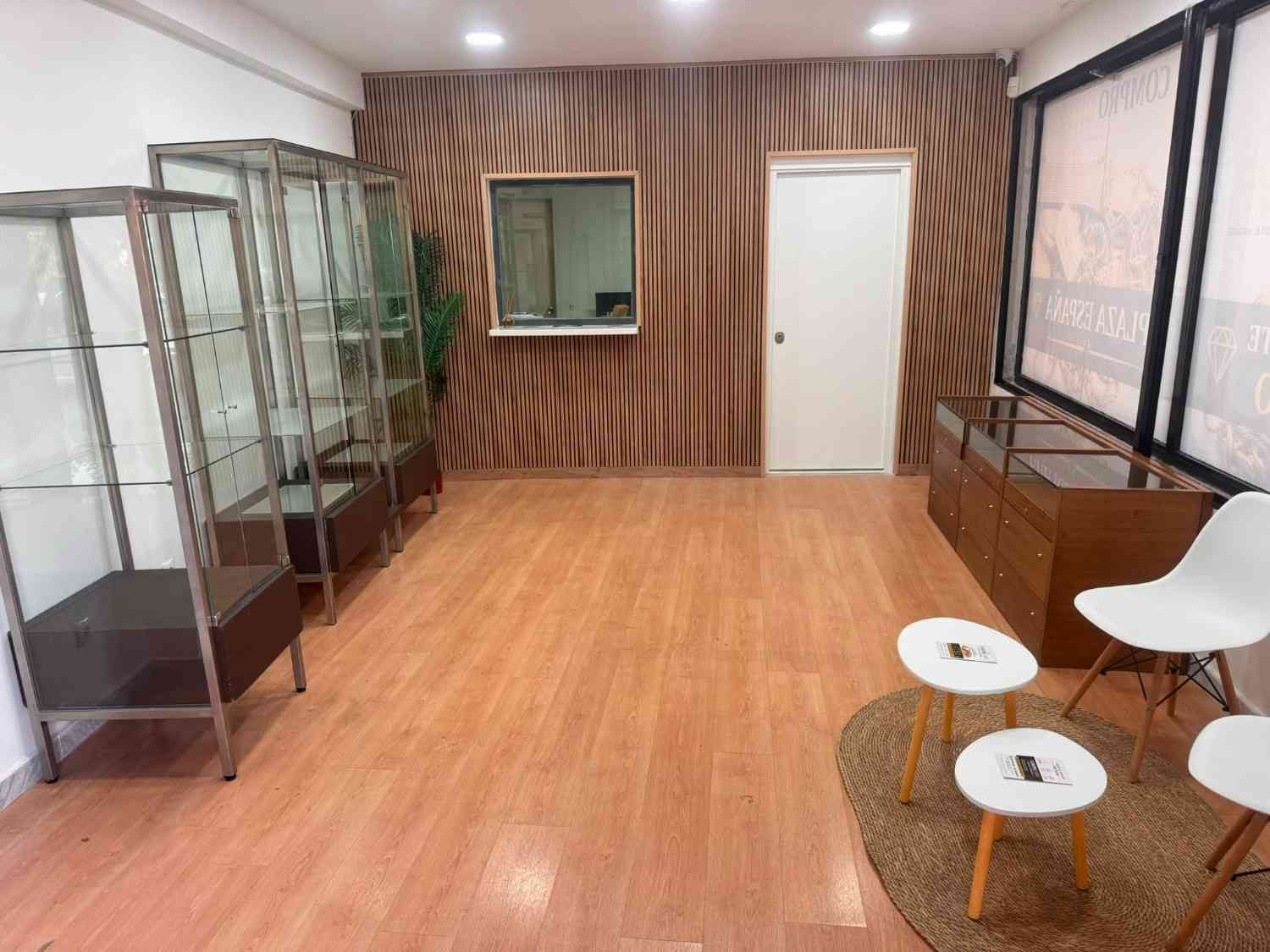 Habitación vacía con suelo de madera, vitrinas de cristal
