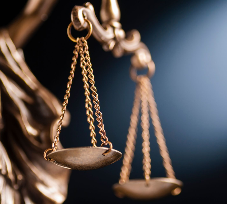 Balance dorée de la justice, gros plan sur fond sombre, en équilibre.