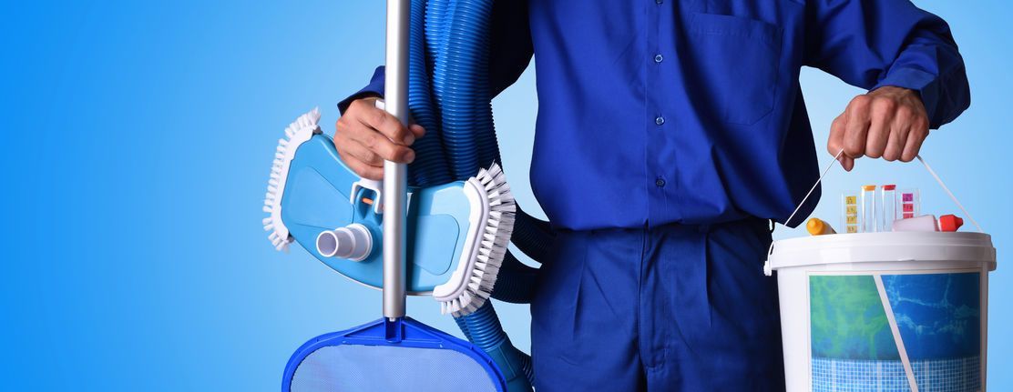 Un hombre con una camisa azul sostiene un trapeador y un balde.