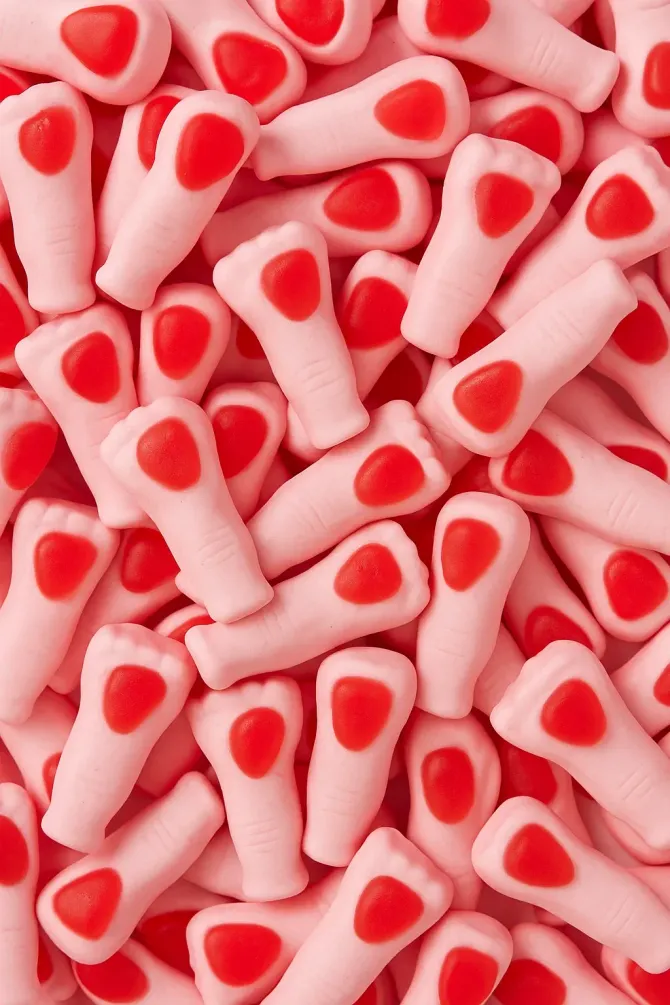 Una pila de dulces rosas con corazones rojos en ellos.