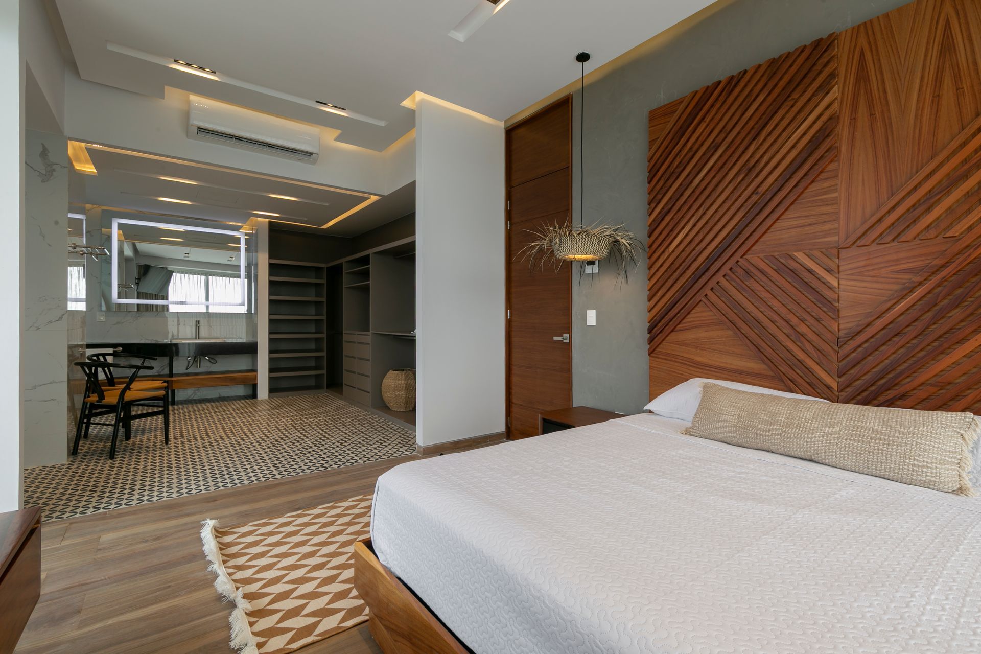 Bedroom with wooden headboard, walk-in closet, and ensuite bathroom.