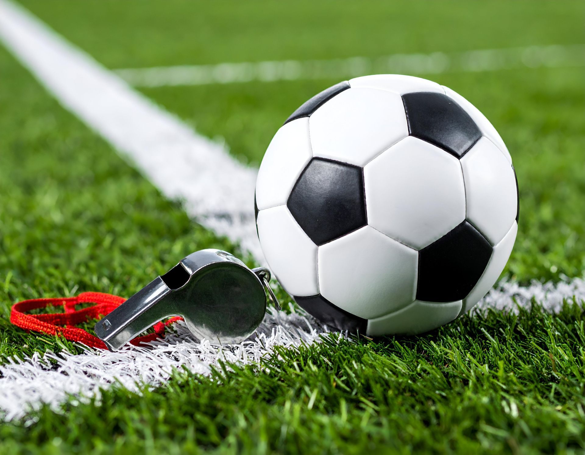 Gros plan sur un sifflet et ballon sur un terrain de foot
