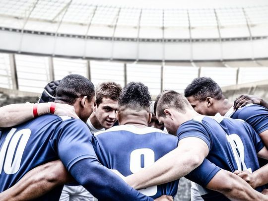 Rugbymen regroupés en cercle sur le terrain