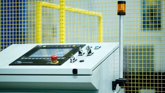 Un primer plano de un panel de control con un botón rojo.