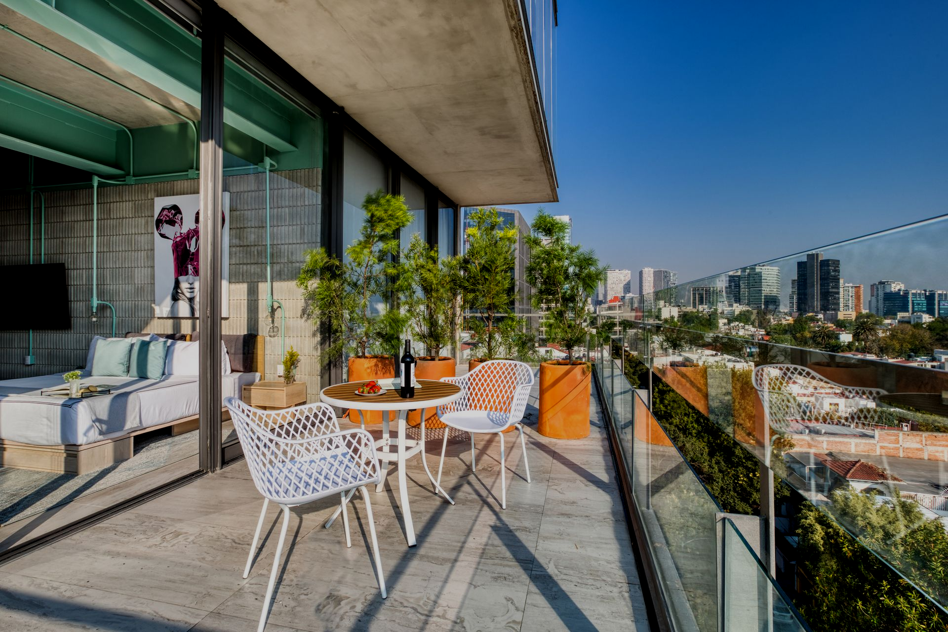 Stylish bedroom with a large bed, floral wall art, and a balcony view through floor-to-ceiling windows