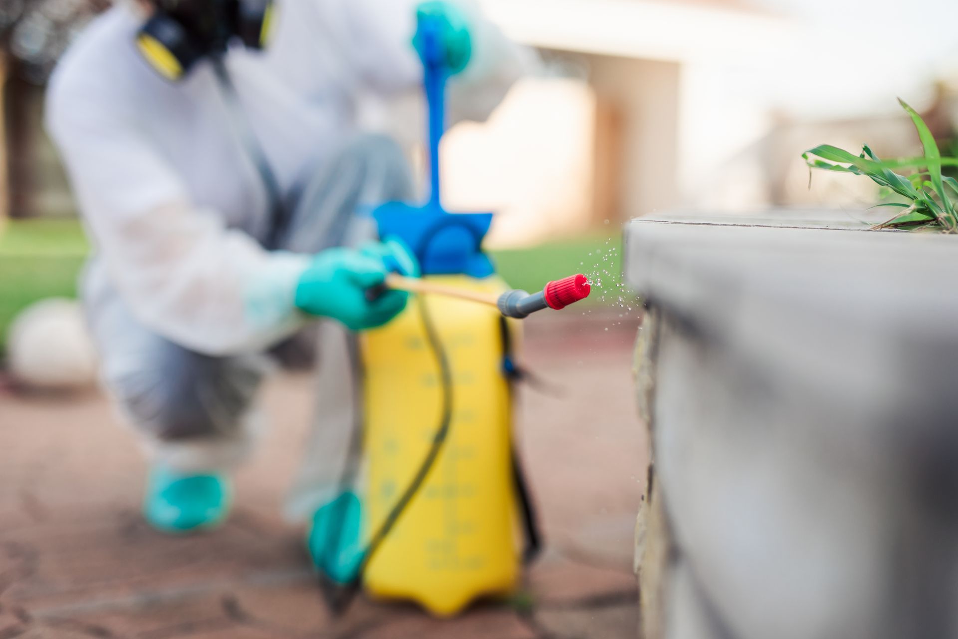 Homme en combinaison qui pulvérise un produit