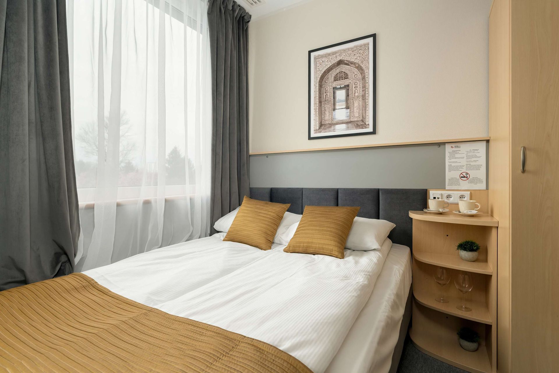 Pokój hotelowy z łóżkiem i oknem.