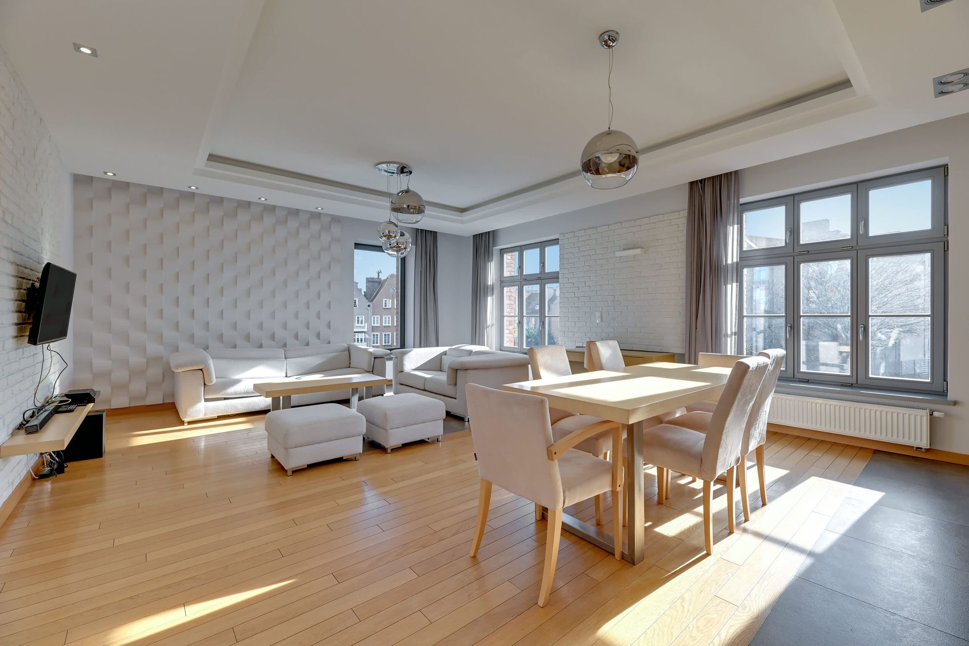 Jasny, nowoczesny salon z jasną drewnianą podłogą, białymi ścianami i stołem jadalnym - Rezydencja Tobiasza w Gdańsku.