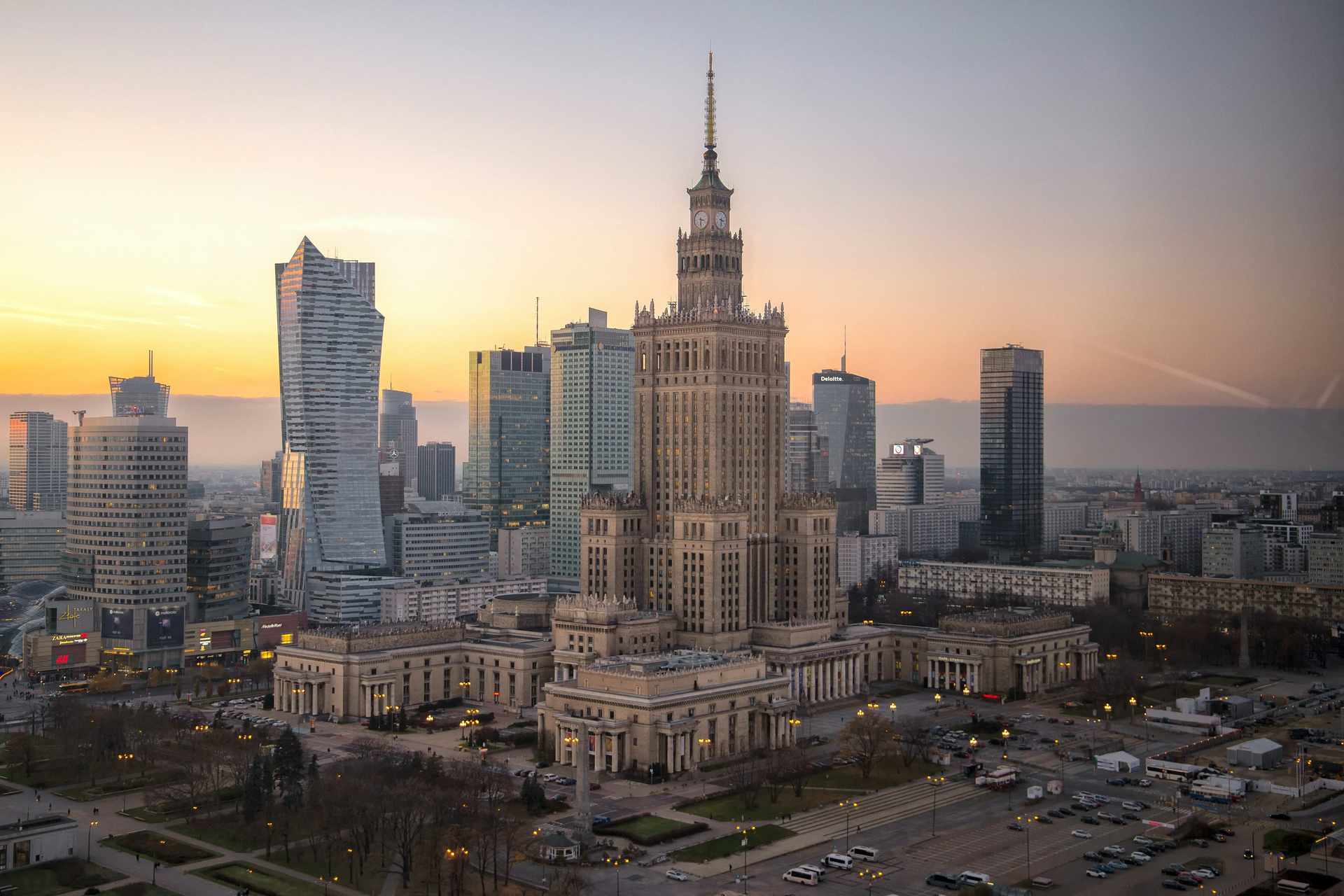 Warsaw, Poland skyline at sunset, featuring the Palace of Culture and Science and other skyscrapers.