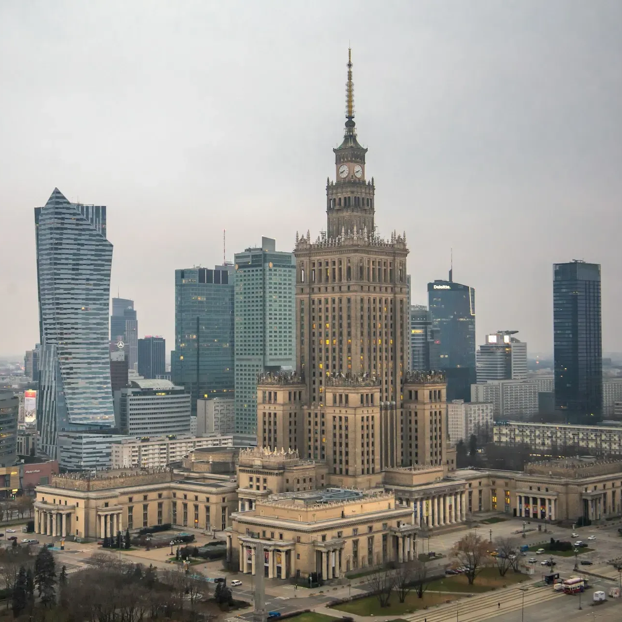 Panorama Warszawy z Pałacem Kultury i Nauki widocznym pośrodku w pochmurny dzień.