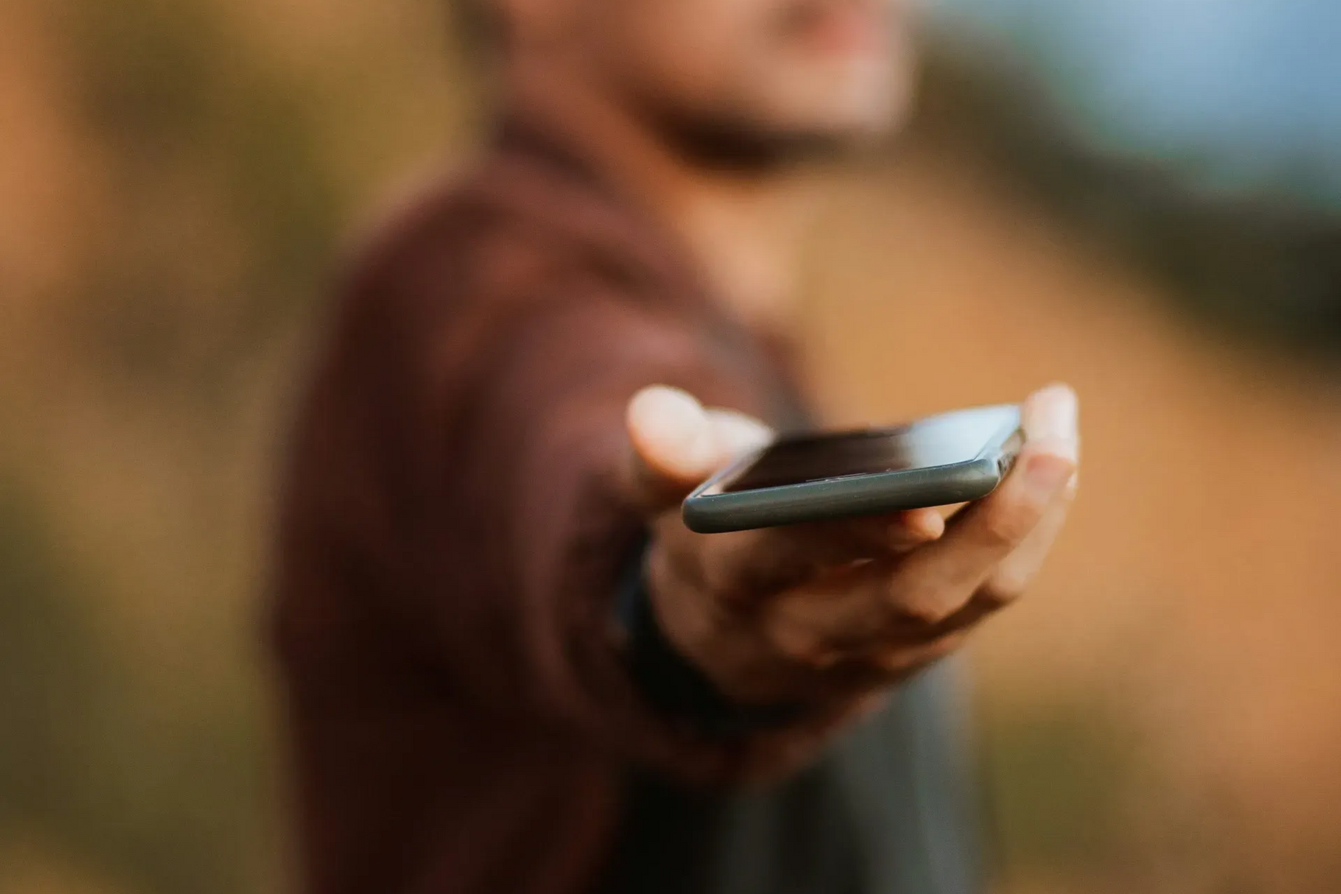 Mężczyzna trzymający telefon w którym ma dostęp do wielu pomocnych aplikacji.