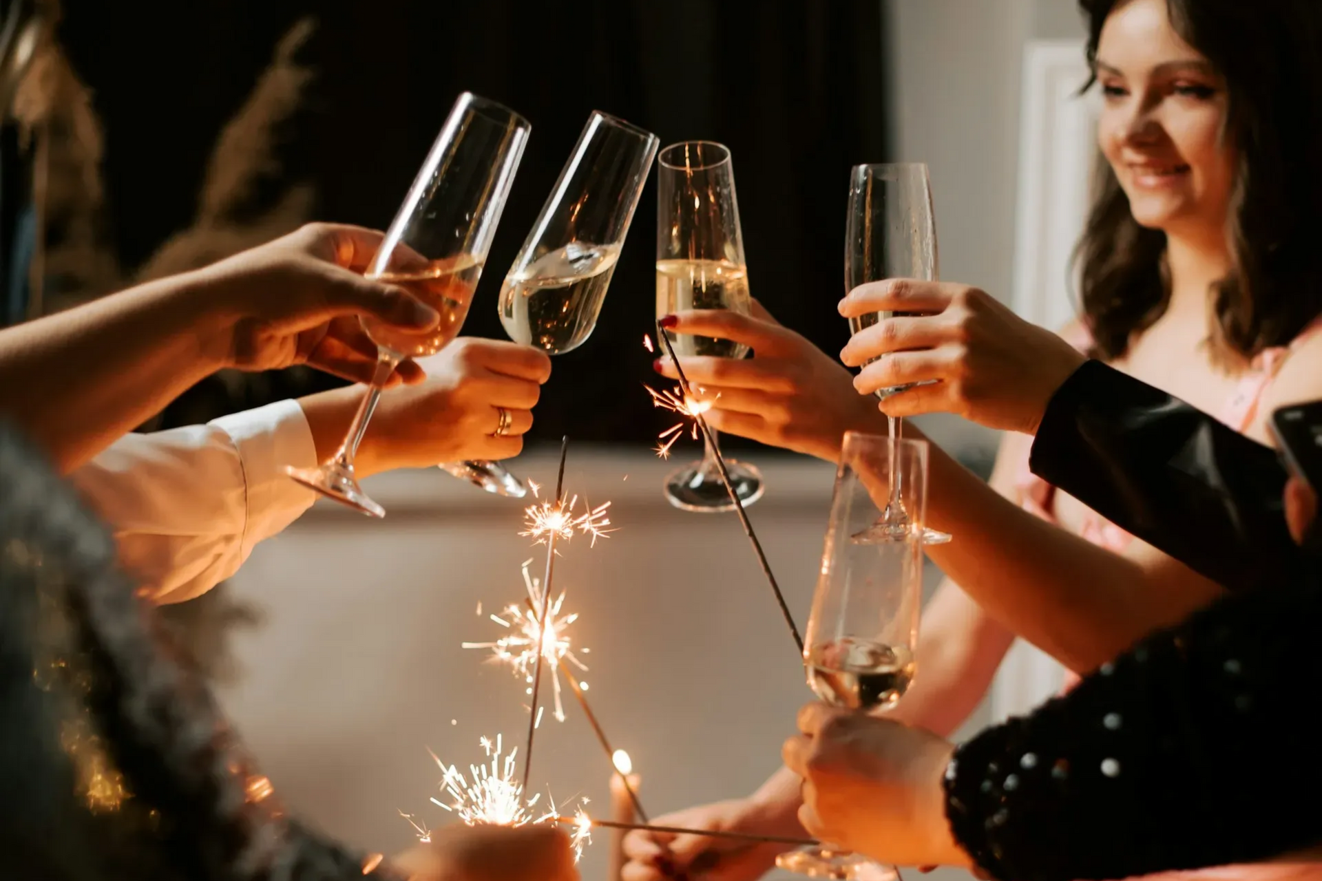 People toasting with champagne flutes and sparklers.