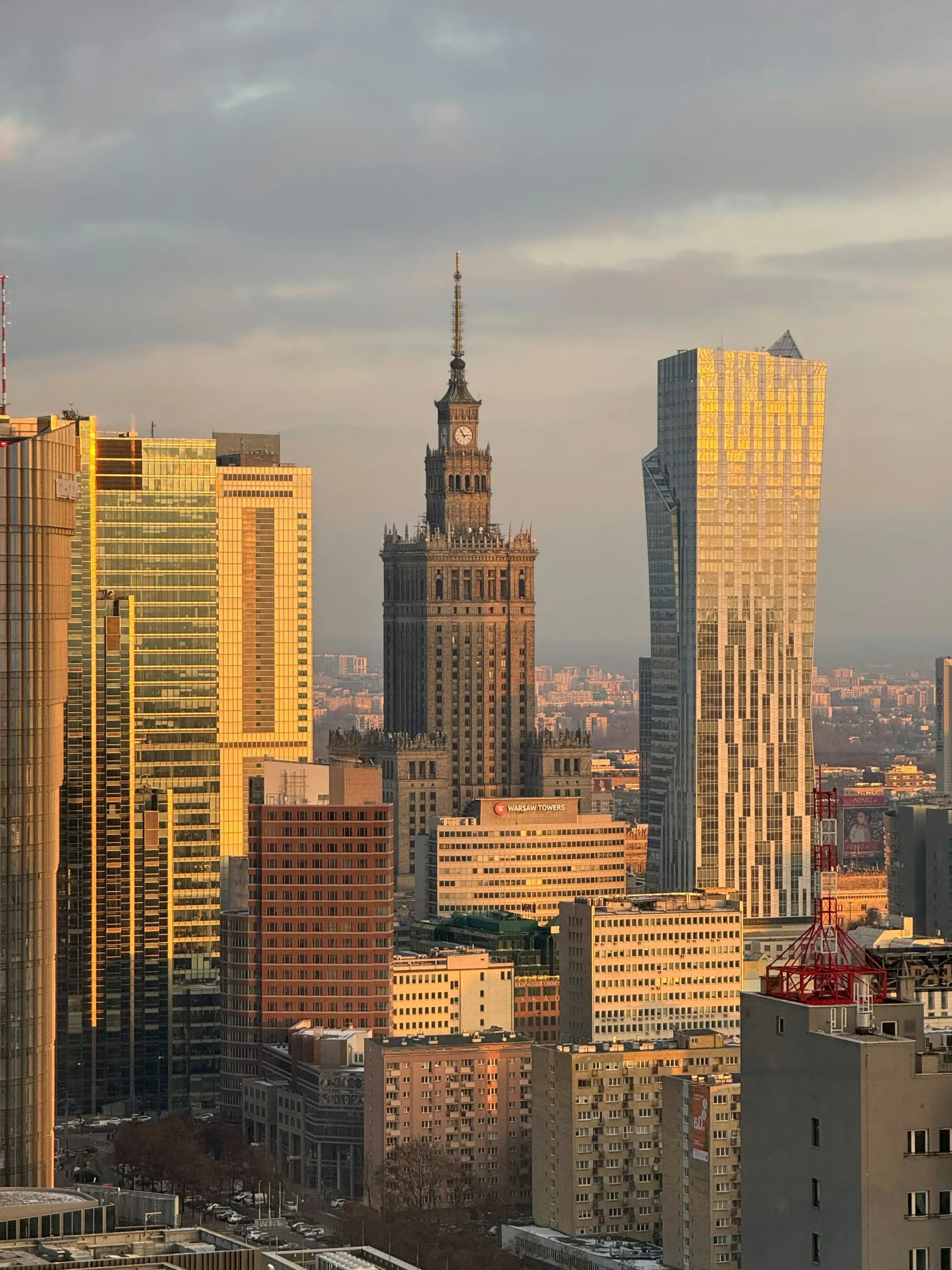 Polska panorama o zachodzie słońca: wieżowce i Pałac Kultury i Nauki w złotym świetle.