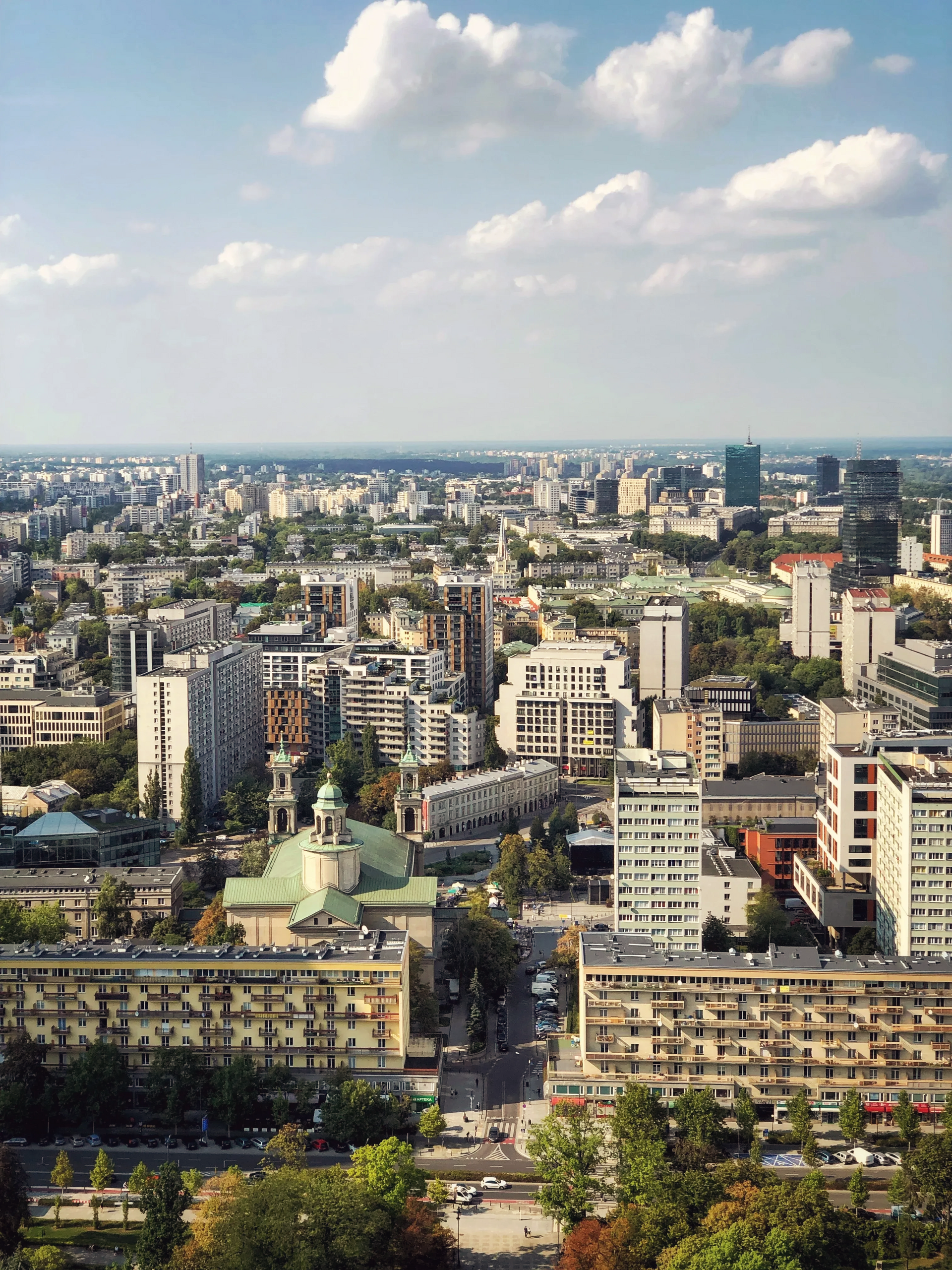 Brukowana ulica w mieście z wieloma budynkami w pochmurny dzień.