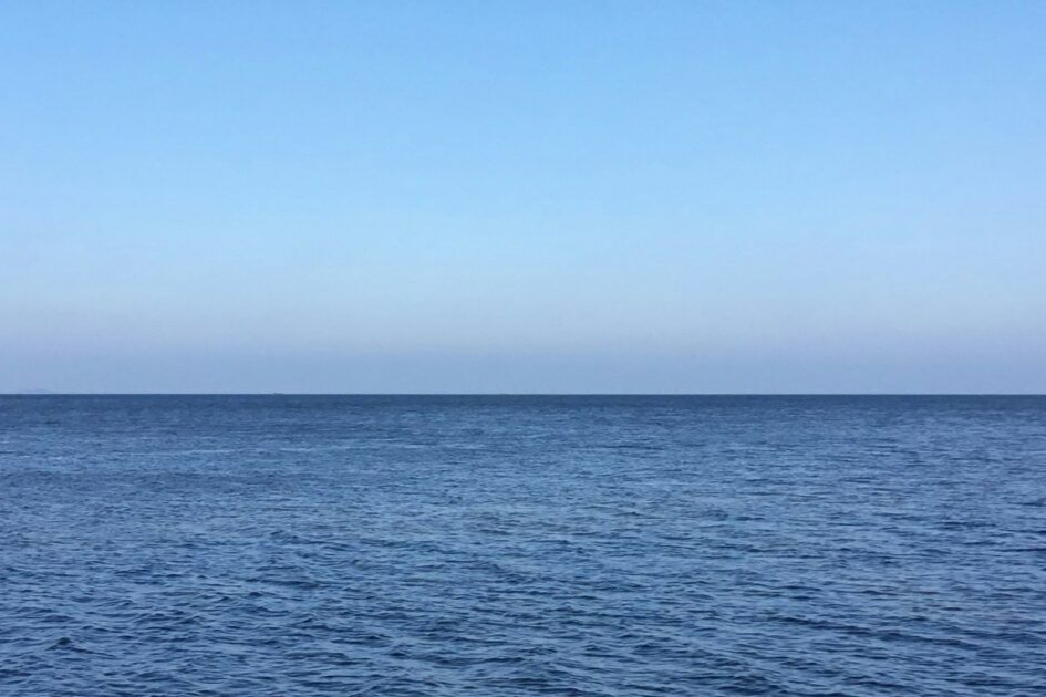 Duży zbiornik wodny na tle błękitnego nieba.