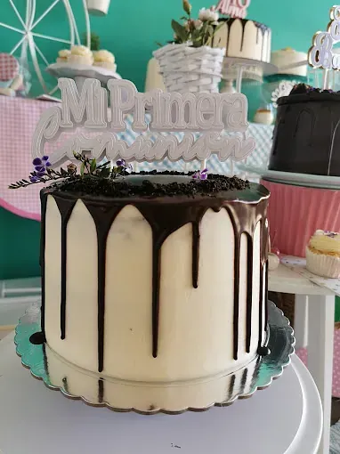 Un pastel blanco con glaseado de chocolate está encima de una mesa.