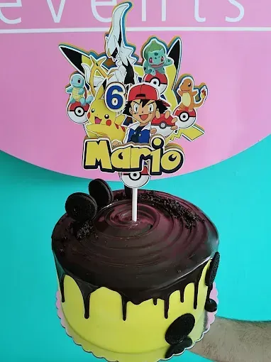Un pastel con un adorno de Pokémon y el nombre Mario en él.