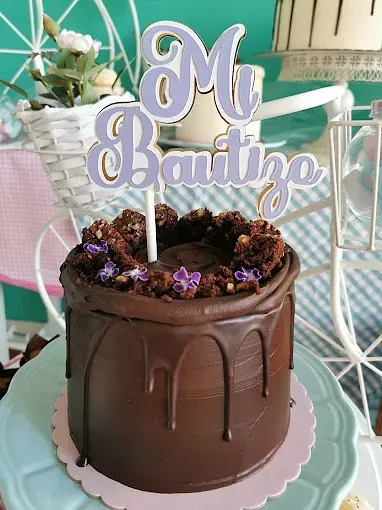 En un plato hay un pastel de chocolate con una decoración morada.