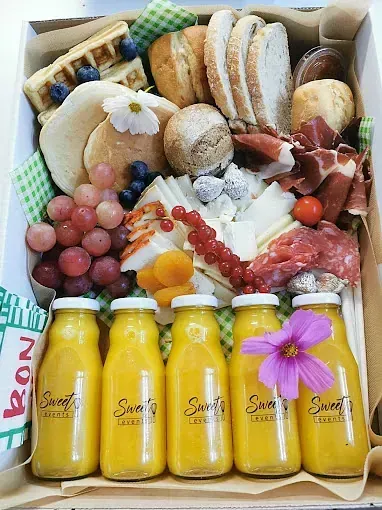 Una caja llena de mucha comida y botellas de jugo.