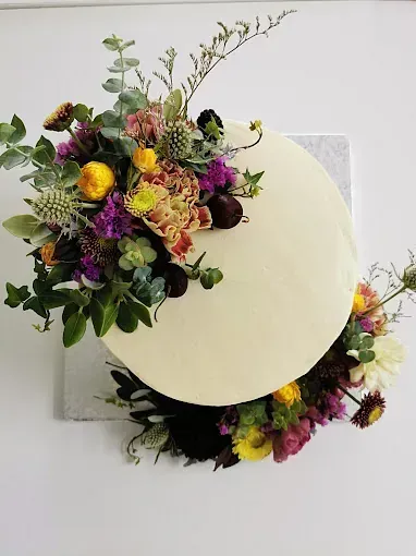 Un pastel blanco con flores encima.