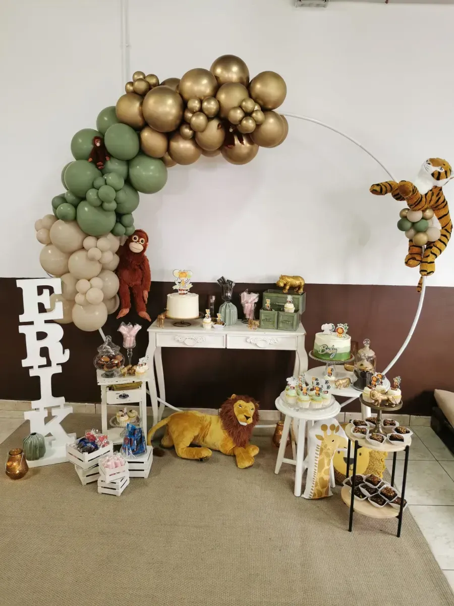 Una mesa con globos y un león de peluche encima.