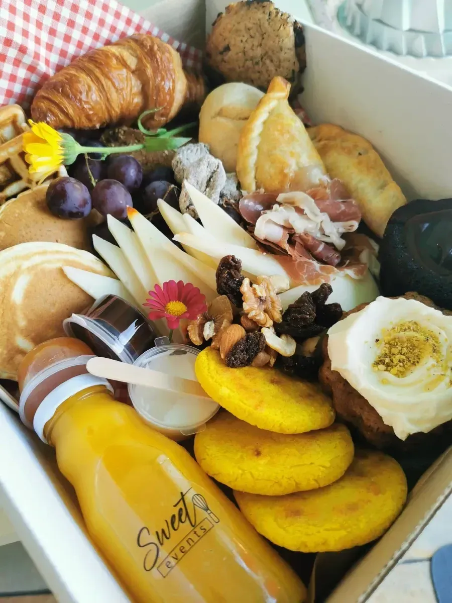 Una caja llena de comida y una botella que dice sweets lounge