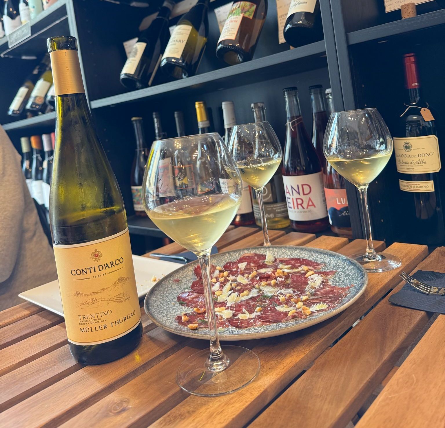 Una botella de vino Conte Barco reposa sobre una mesa de madera.
