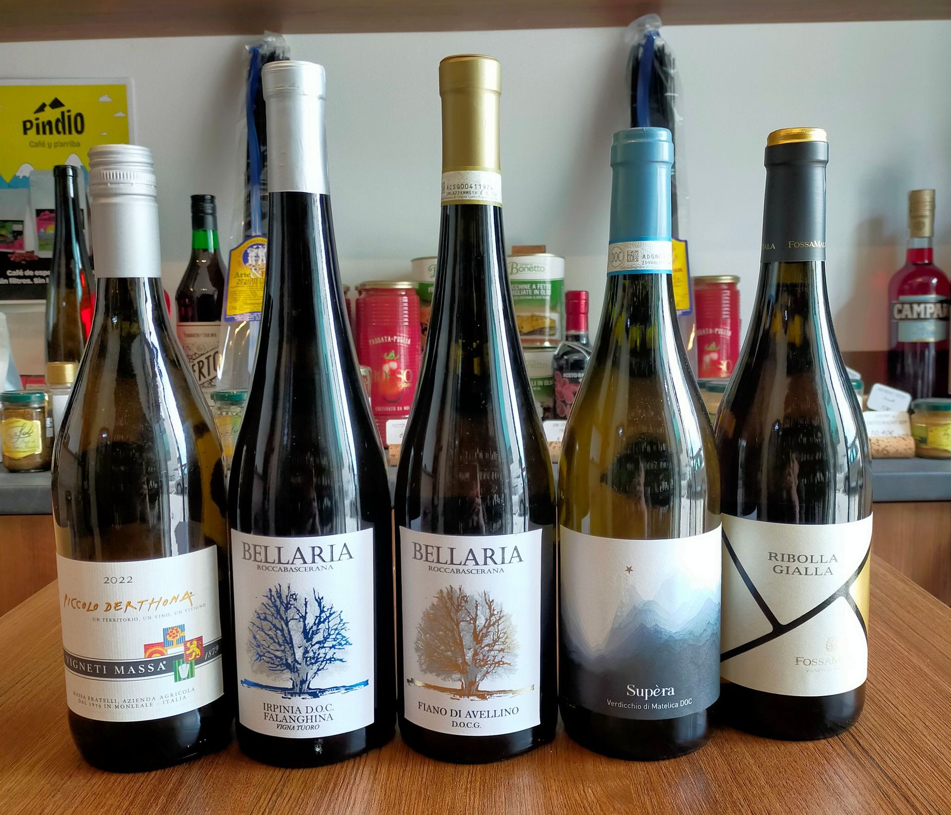 Seis botellas de vino están alineadas en una mesa de madera.