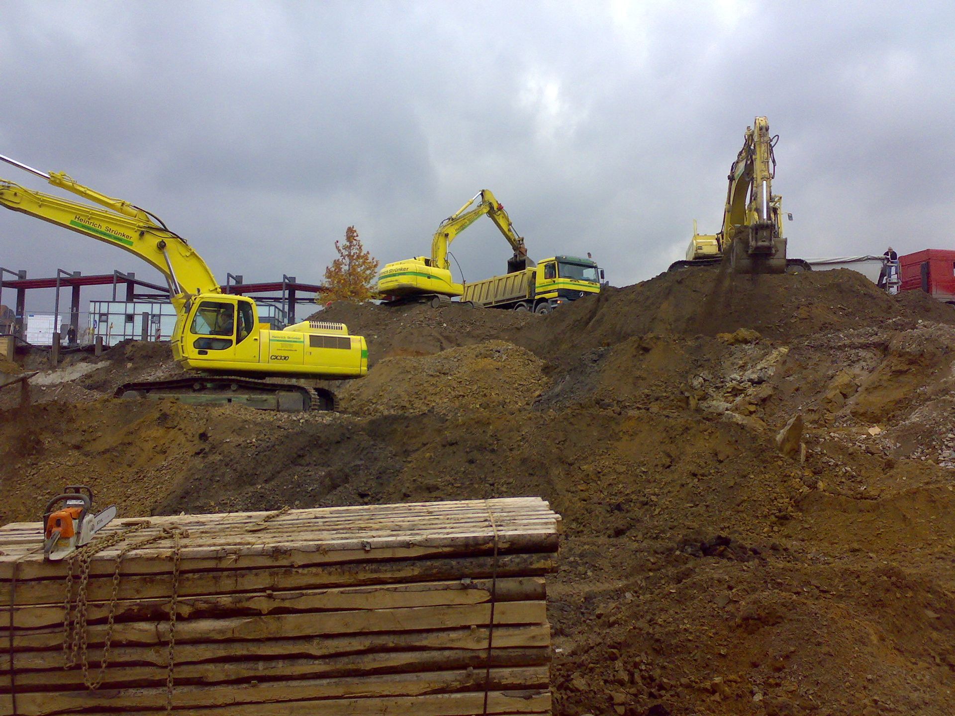 Eine Gruppe von Baufahrzeugen arbeitet auf einem Erdhügel
