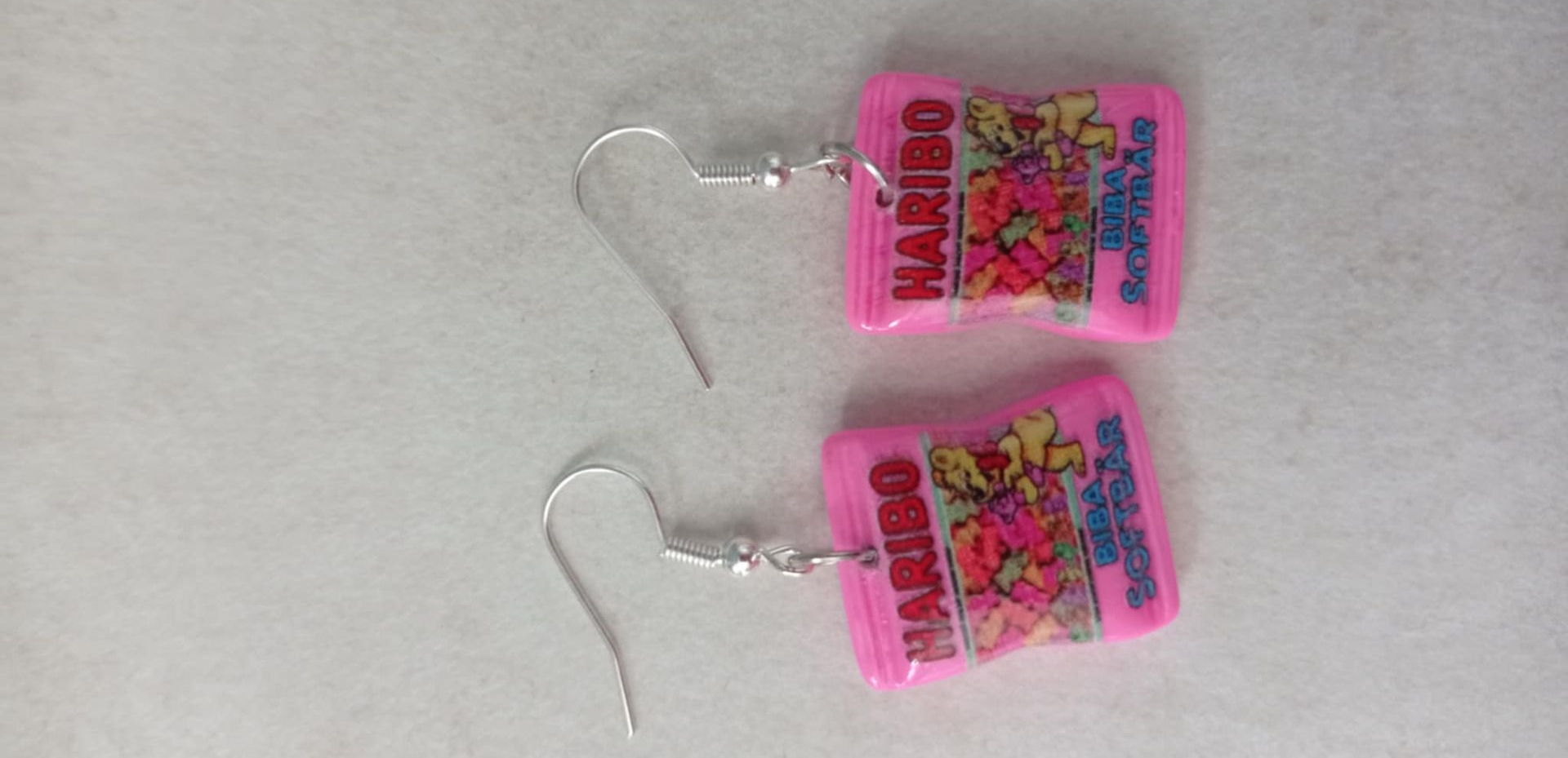 Paire de boucles d'oreilles en forme de bonbons Haribo roses avec crochets argentés.