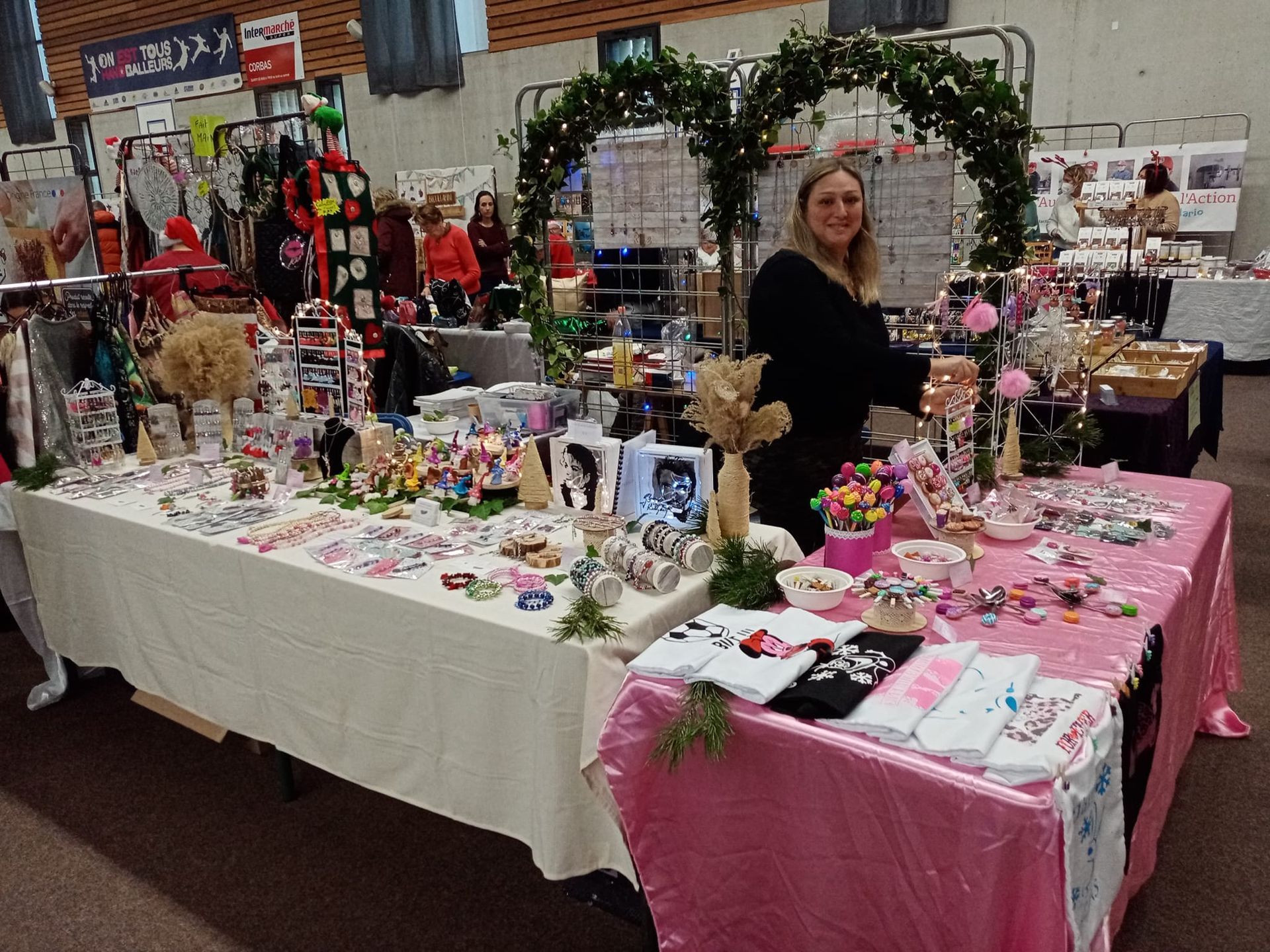 Personne fabriquant des bijoux à un établi, tenant un bracelet en argent avec des outils et des matériaux.