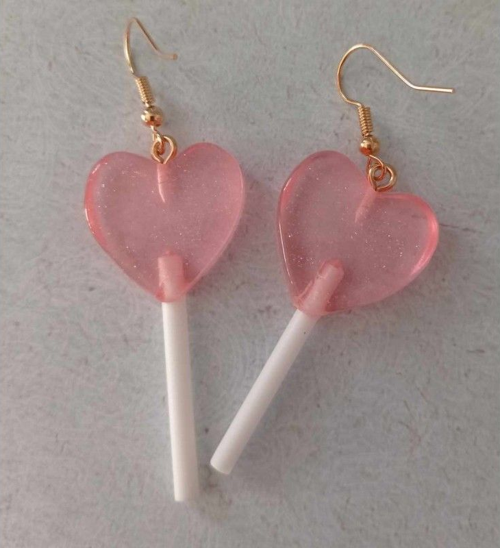 Boucles d'oreilles sucette roses en forme de cœur avec crochets dorés.