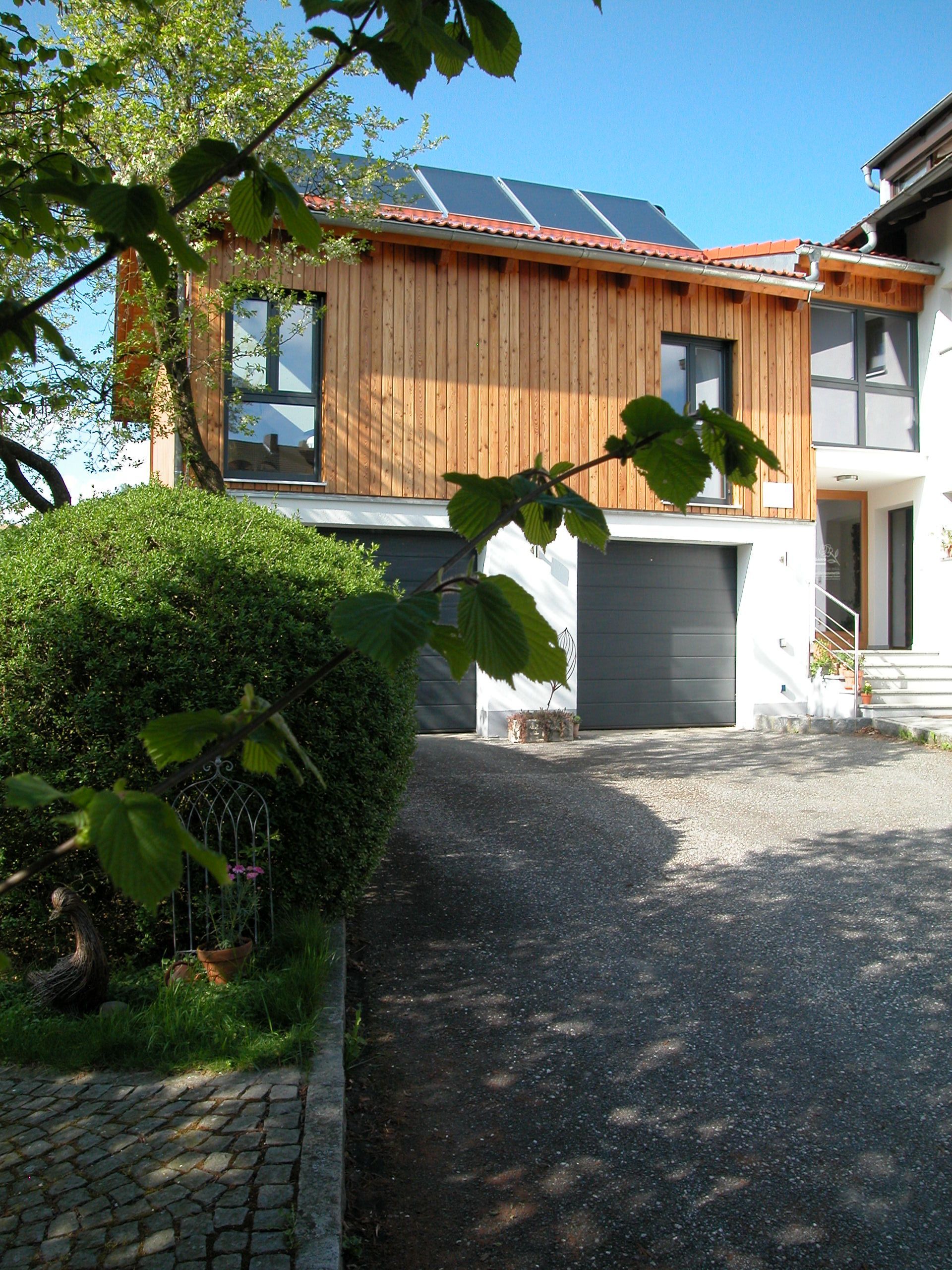 Ein Haus mit Garage und Sonnenkollektoren auf dem Dach. Foto von Eder Christiane Kosmetikstudio