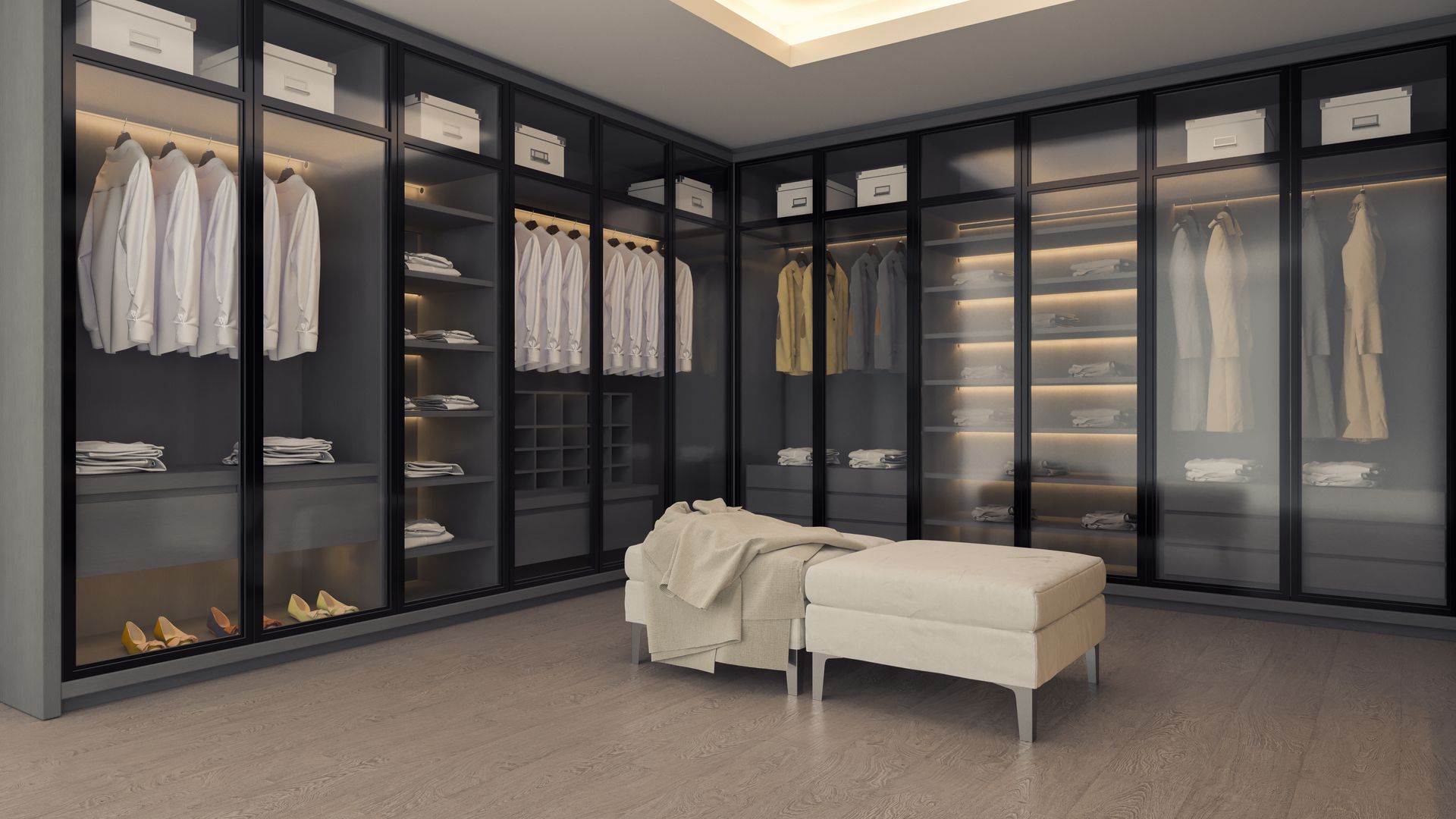 Un vestidor moderno con armarios con puertas de cristal oscuro, iluminación integrada y un banco de tonos neutros